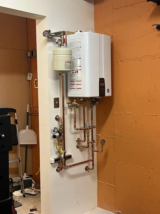 Plumbing technician inspecting water heater connections in Laurel